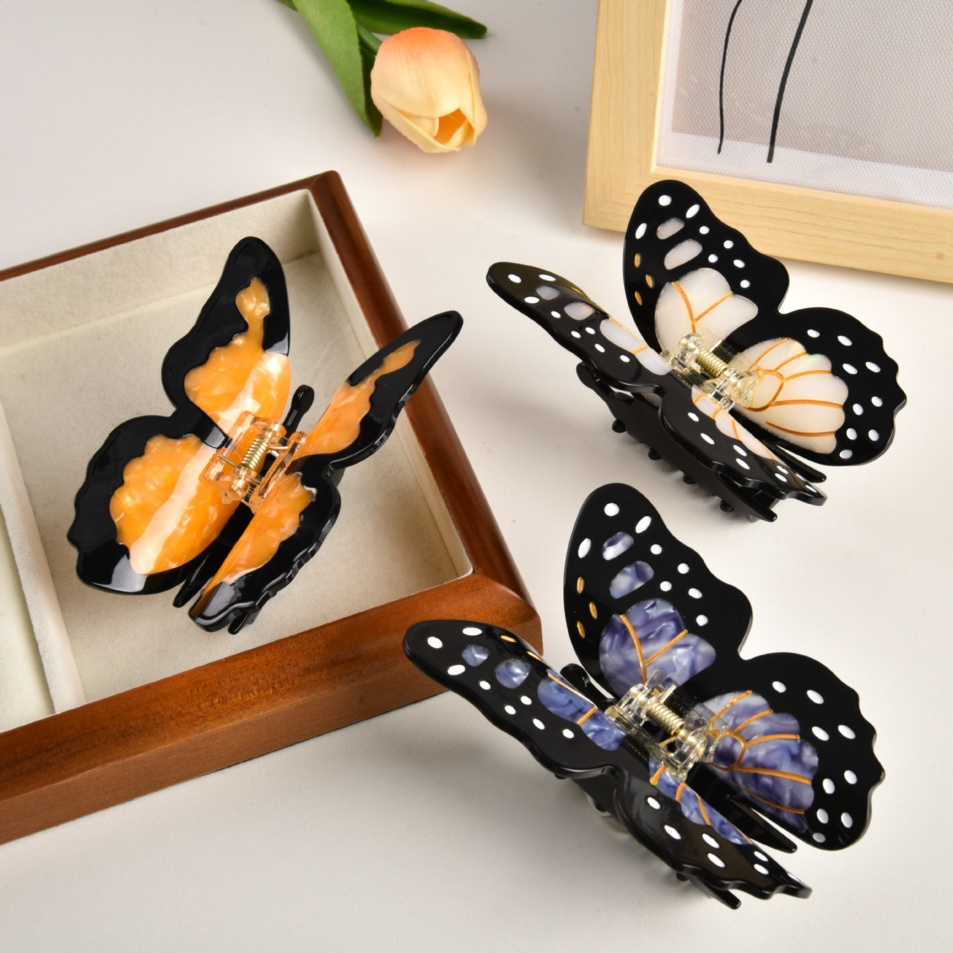 Butterfly-shaped claw clips in orange, cream and purple