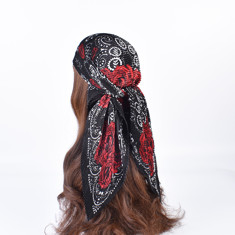 Black scarf with red roses and white patterns styled in the hair